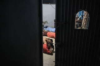 Authorities detain a group of men during a police raid in a suburb of Guayaquil, Ecuador, on May 30, 2023. (Victor Moriyama/The New York Times)