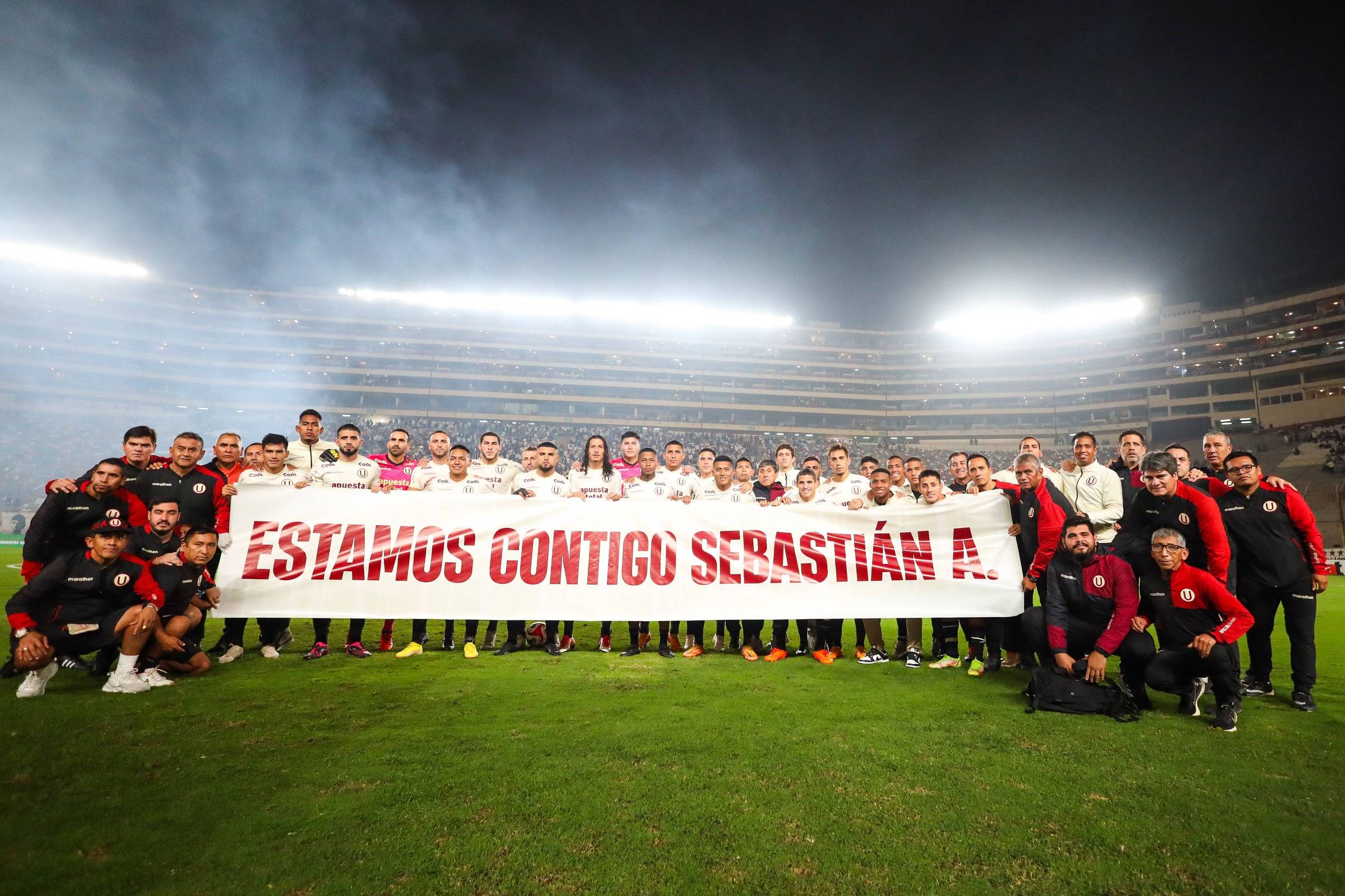 Universitario cast poses with a message of support for coach suspected of racism