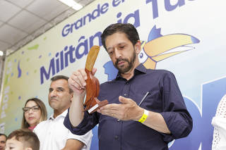 O prefeito Ricardo Nunes (MDB) segura estatueta de tucano, mascote do PSDB