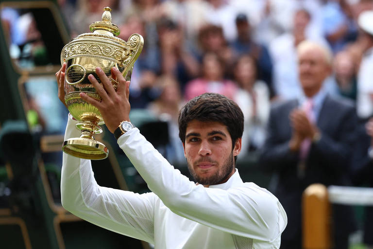 Alcaraz levanta troféu após vencer o torneio de Wimbledon, neste domingo (16)
