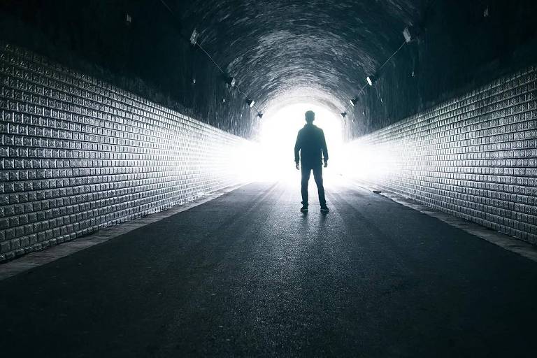 Homem em túnel com luz ao fundo