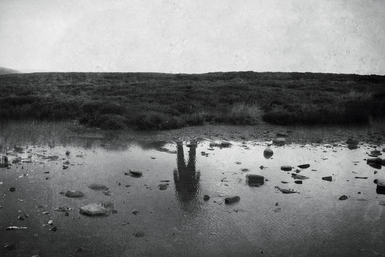 Reflexo de homem em poça d'água

