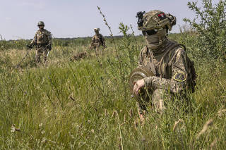 Ukrainian soldiers from the 102nd Territorial Defense BrigadeÕs mine detonation unit carry inactive anti-tank mines during training exercises near the city of Huliaipole, in the Zaporizhzhia region of Ukraine on Saturday, June 24, 2023. (David Guttenfelder/The New York Times)