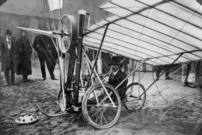 Santos Dumont em uma máquina voadora composta por uma bicicleta ligada a asas