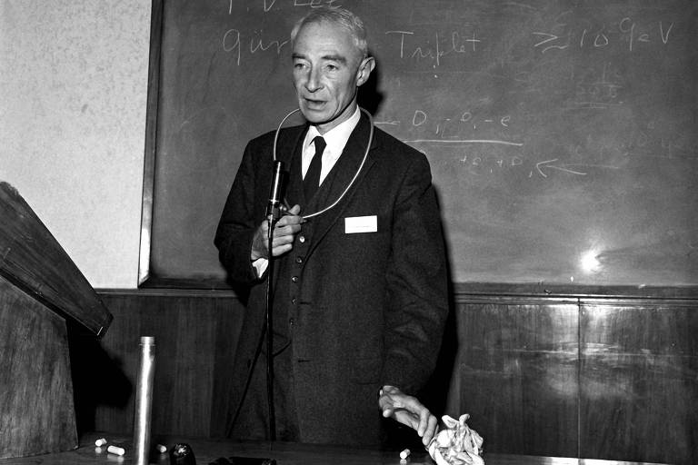 Físico Robert Oppenheimer posa em frente a uma lousa com fórmulas matemáticas