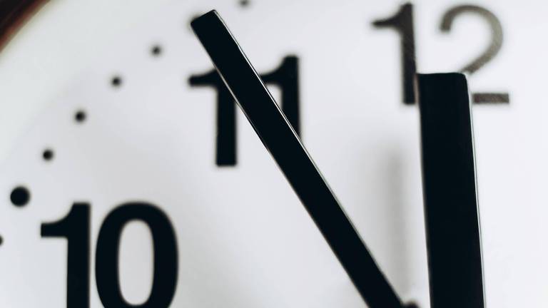 Imagem de parte de um relógio de ponteiros, aparecendo os números 10, 11 e 12