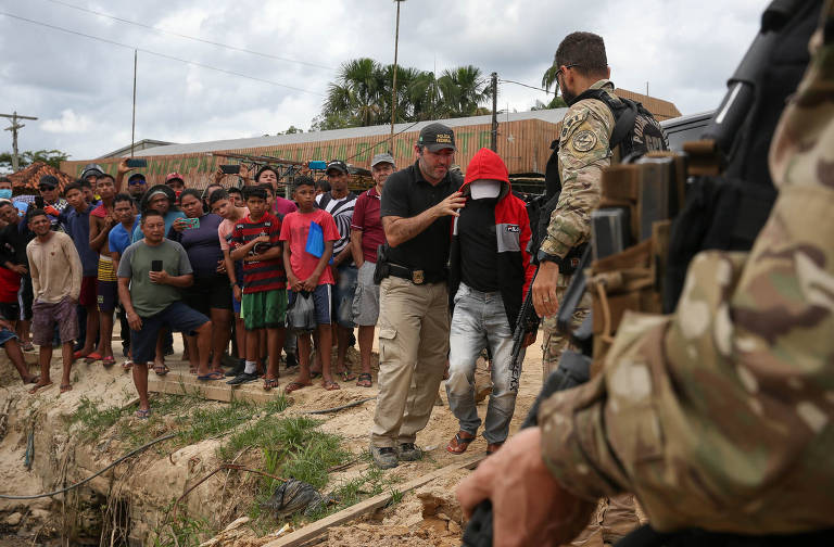 Uma a cada cinco mortes violentas intencionais no Brasil no ano passado aconteceram nos nove estados da Amazônia Legal. O índice é o mais alto do país. Em 2022, Acre, Amazonas, Amapá, Maranhão, Mato Grosso, Pará, Rondônia, Roraima e Tocantins tiveram, somados, 9.302 MVIs (mortes violentas intencionais). O número equivale a 19,57% do registrado em todo o território nacional. Na imagem, em 15 de junho de 2022, policiais federais conduzem um dos suspeitos presos acusados do homicídio de Bruno e Dom em Atalaia do Norte