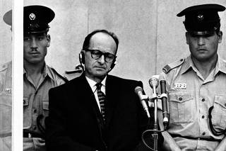 File photograph of Adolf Eichmann, the Nazi S.S. colonel who headed the Gestapo's Jewish Section, flanked by Israel police