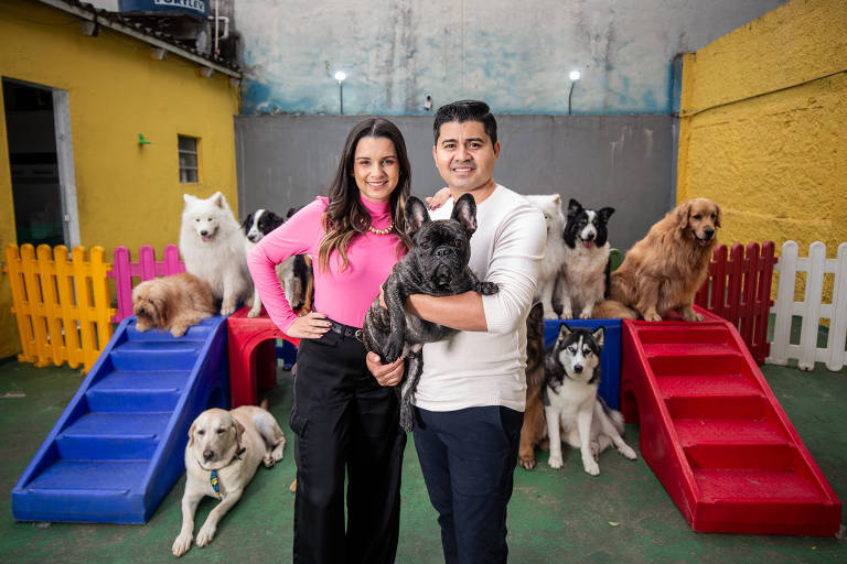 O casal Dan Batista e Cleber Conceição e sua clientela canina, na Comport Pet, em São Paulo