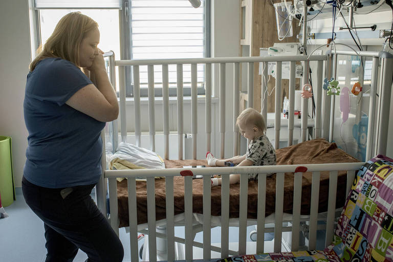 .Anna Kolesnikova espera ao lado de seu filho Mikola enquanto recebe tratamento no Hospital Infantil Ohmatdit, em Kiev