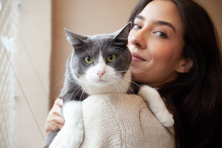 Foto mostra Fernanda segurando seu gato no ombro