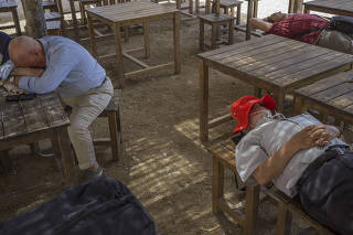 Men take a siesta at a park in Toledo, Spain, June 14, 2023. (Samuel Aranda/The New York Times)