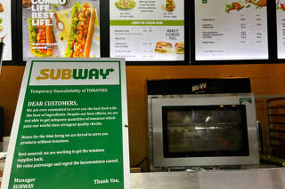 A notice on the temporary unavailability of tomatoes is seen at a Subway outlet at an airport terminal in New Delhi