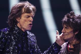 Singer Mick Jagger greets guitarist Ronnie Wood of The Rolling Stones as they perform at the Barclays Center in New York