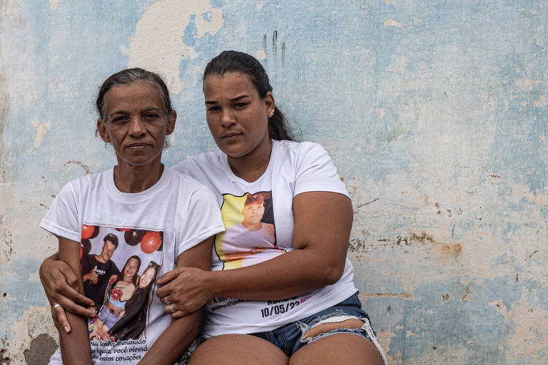 Filha abraça mãe; as duas usam camiseta com fotos de Kaylan coma família