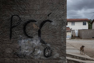 Muro de casa na comunidade, pichado com nome da facção criminosa PCC