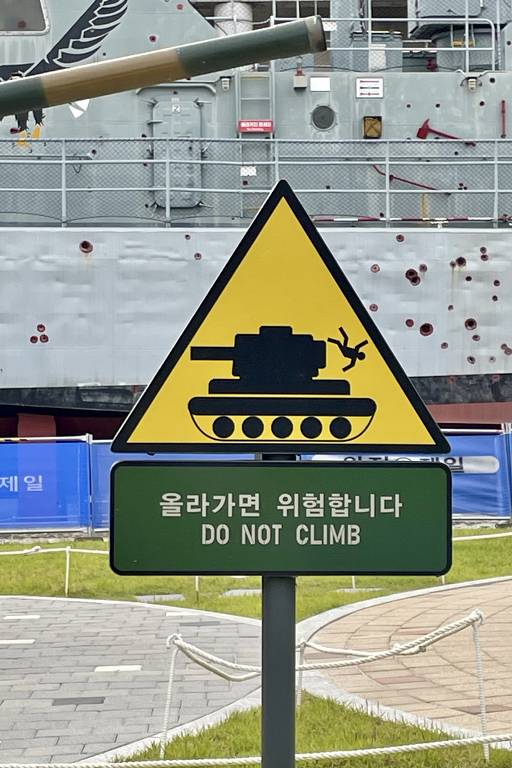 Placa pede a visitante para não subir em tanques expostos no Memorial da Guerra da Coreia, em Seul