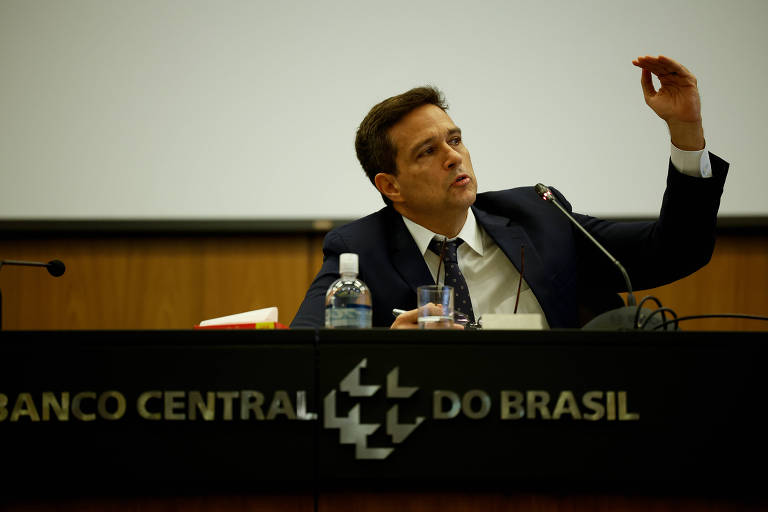Roberto Campos Neto discursa ao microfone, em bancada do banco central