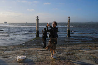 Tourists take photos at Cais das Colunas in Lisbon