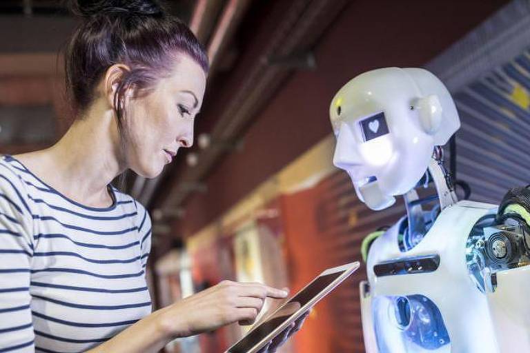 Mulher com tablet na mão em frente a um robô.