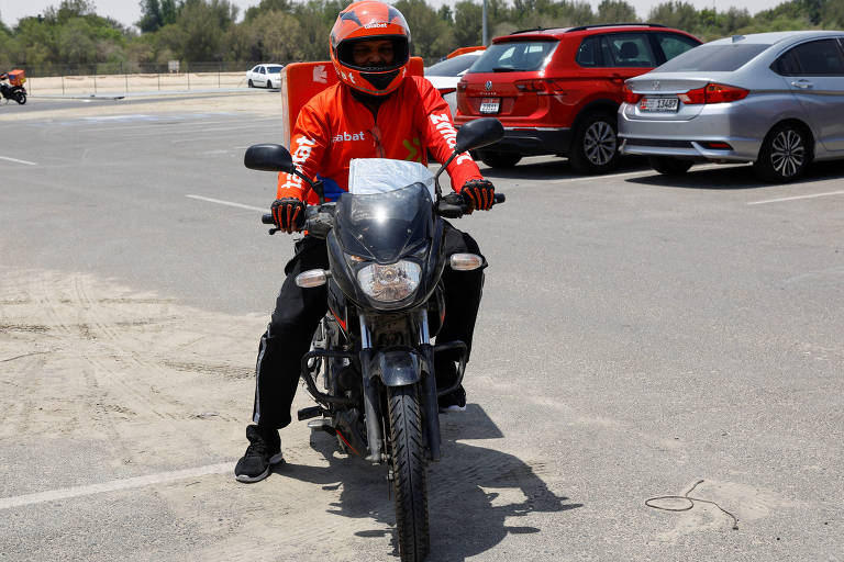 Motoboy com sua moto em uma entrega