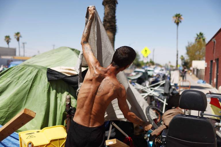 Pessoa em situação de rua organiza seus pertences em Phoenix, a capital do Arizona, uma das regiões mais afetadas pela atual onda de calor nos EUA