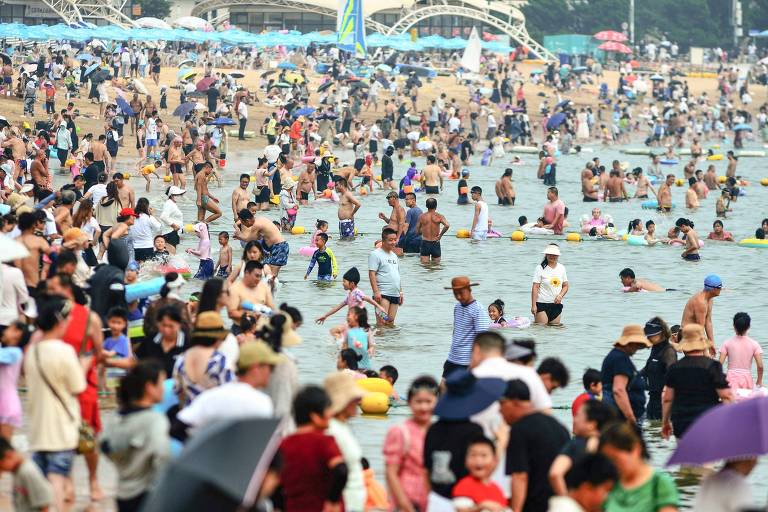 Chineses lotam praia em Qingdao para se refrescar do calor recorde neste mês de julho no país