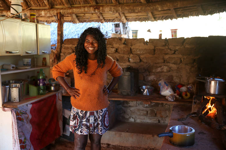 A quilombola Maria Helena Rodrigues posa para foto com as mãos na cintura na sua cozinha