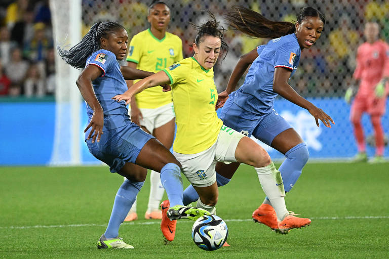 A volante Luana, do Brasil, usando a camisa amarelo de número 5, tenta fugir da marcação francesa na partida em Brisbane pela Copa do Mundo