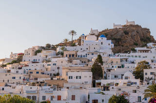 Homes with white-washed walls, which helps to keep the interiors cooler, in Chora, on the Mediterranean island of Ios, Greece, Aug. 10, 2022. (Maria Mavropoulou/The New York Times)