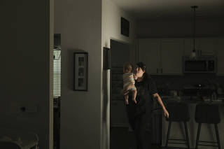 Allie Strickland carries her 9-month-old son, August, as she prepares to leave her home for the only outing of the day, a trip across town to the pharmacy, in Goose Creek, S.C. on June 1, 2023. (Travis Dove/The New York Times)