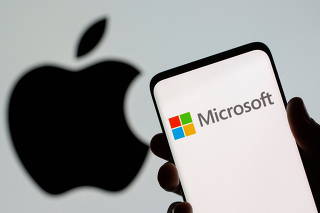 FILE PHOTO: Microsoft logo is seen on the smartphone in front of displayed Apple logo in this illustration taken