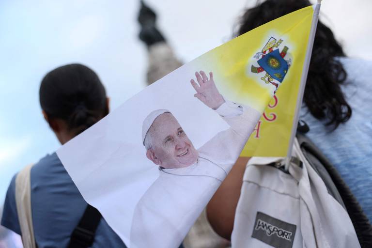 Participante carrega bandeira com a foto do papa Francisco, que desembarca em solo português na quarta (2)