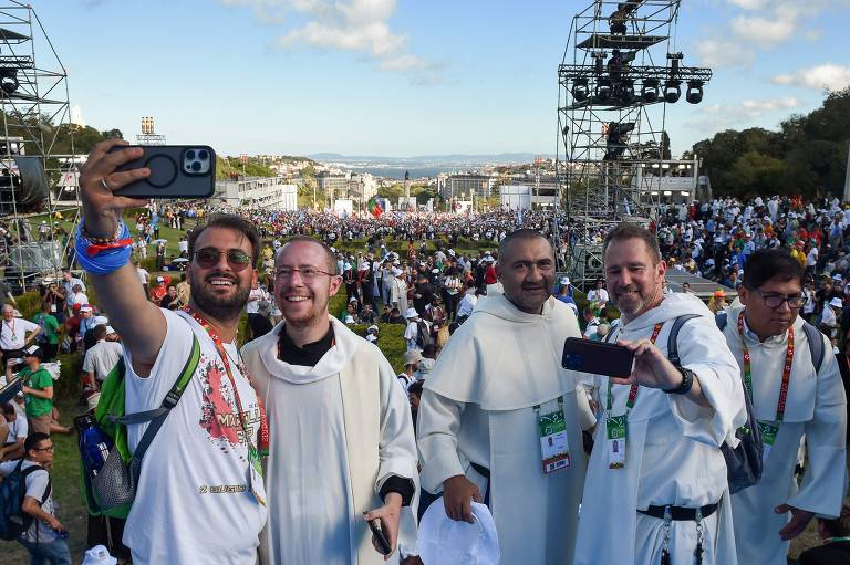 Grupo de padres tira selfies enquanto espera pelo início da missa