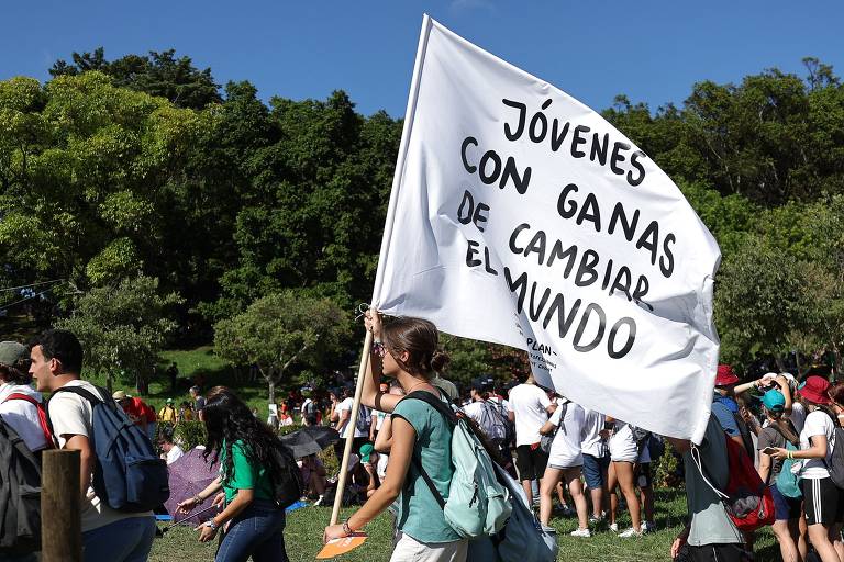 Religioso carrega bandeira na qual se lê: 'Jovens com vontade de mudar o mundo', em espanhol