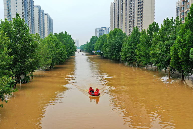 Socorristas se deslocam de bote em avenida alagada na província de Hebei, no norte da China