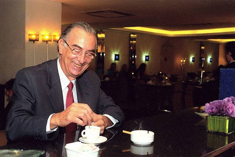 Em foto colorida, o músico Theo de Barros aparece tomando um café