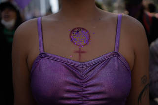 A woman wears makeup with the symbol of Venus, during the International Women's Day March in Mexico City on March 8, 2022. (Victoria Razo/The New York Times)