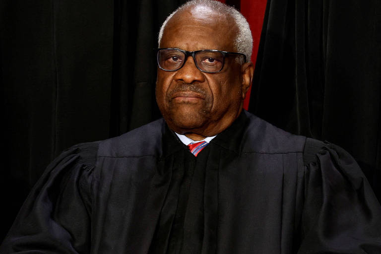 Homem negro de cabelo grisalho, um pouco careca, vestindo toga de juiz em cima de terno, olha para a câmera