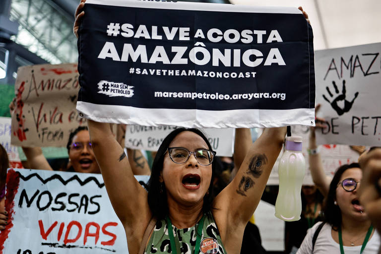 manifestantes levantam cartazes com texto "salve a costa amazônica"