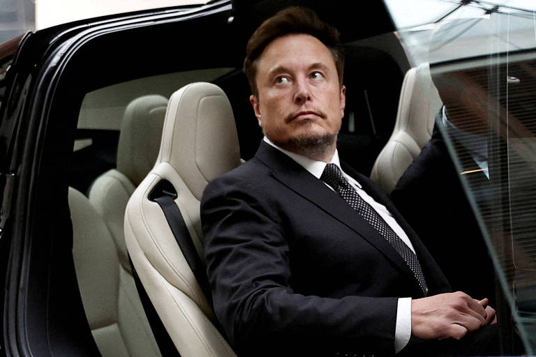 Imagem mostra Musk olhando para o lado dentro de um carro de luxo