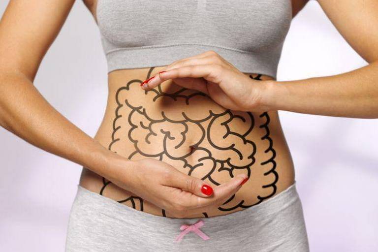 mulher mostra a barriga com intestino desenhado nela