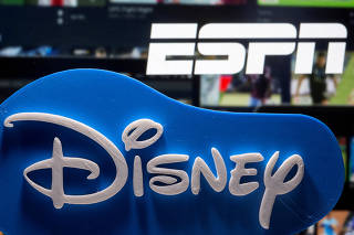 FILE PHOTO: Photo illustration of a 3D-printed Disney logo seen in front of the ESPN+ logo