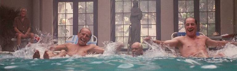 Cena do filme "Cocoon" (1985) mostra (da esq. para a dir.) os atores Don Ameche, Wilford Brimley, Hume Cronyn e Jack Gilford. Os últimos três sorriem e brincam dentro de uma piscina. O primeiro observa, sentado fora da piscina. O filme dirigido por Ron Howard ganhou dois Oscars em 1986 