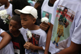 Friends and relatives of 13-year-old boy Thiago Menezes Flausino mourn during his funeral in a cemetery in Rio de Janeiro