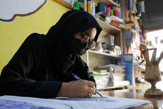 Khushi, 19, draws on a paper in an art studio in Mazar-i-Sharif