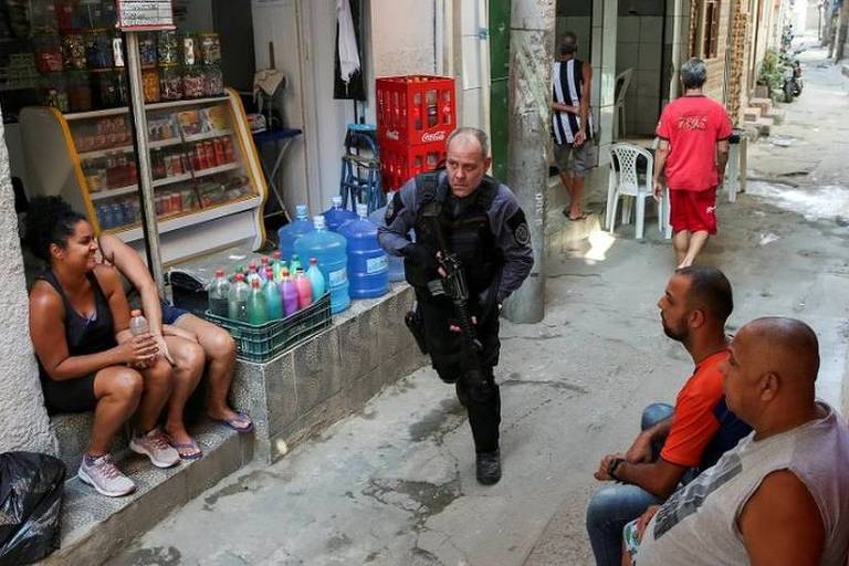 Policial toma posição em meio a operação na favela do Jacarezinho, no Rio