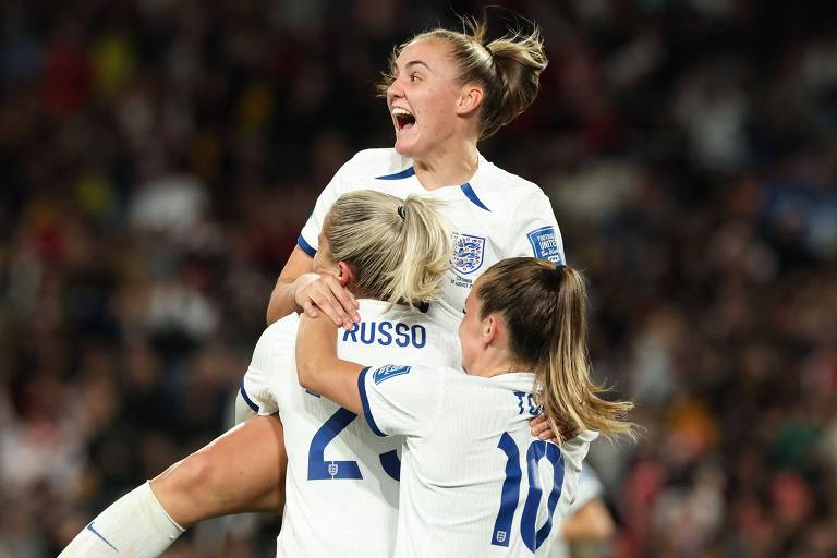 Alexia Russo, de costas, é abraçada por duas outras jogadoras na comemoração do gol da virada da seleção da Inglaterra