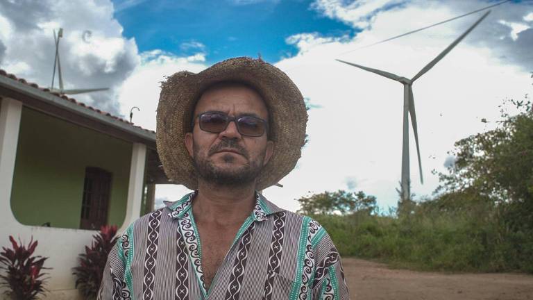 O agricultor José Salgado em frente a torres de energia eólica