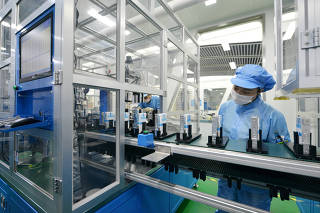 Workers are seen at the production line of lithium-ion batteries for electric vehicles (EV) at a factory in Huzhou
